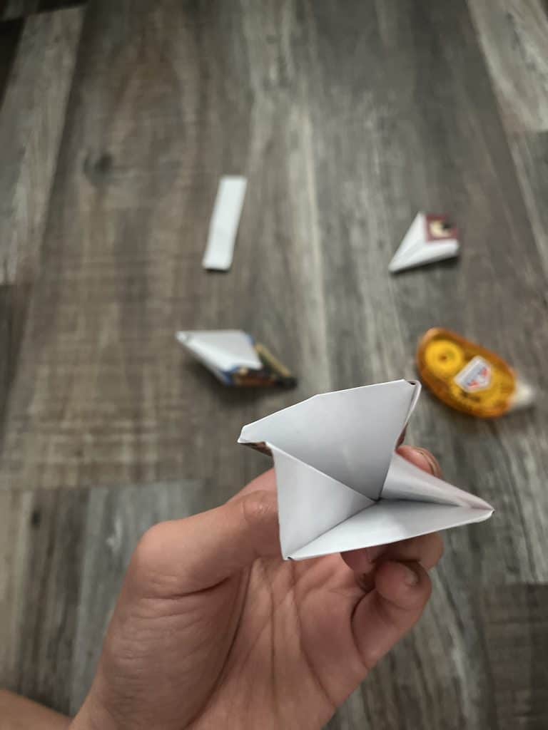 paper held in hand in triangles