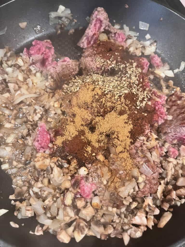 beef, veggies and seasonings cooking in pan