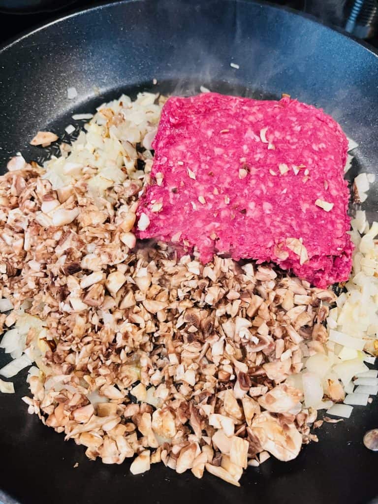 vegetables and beef cooking in pan